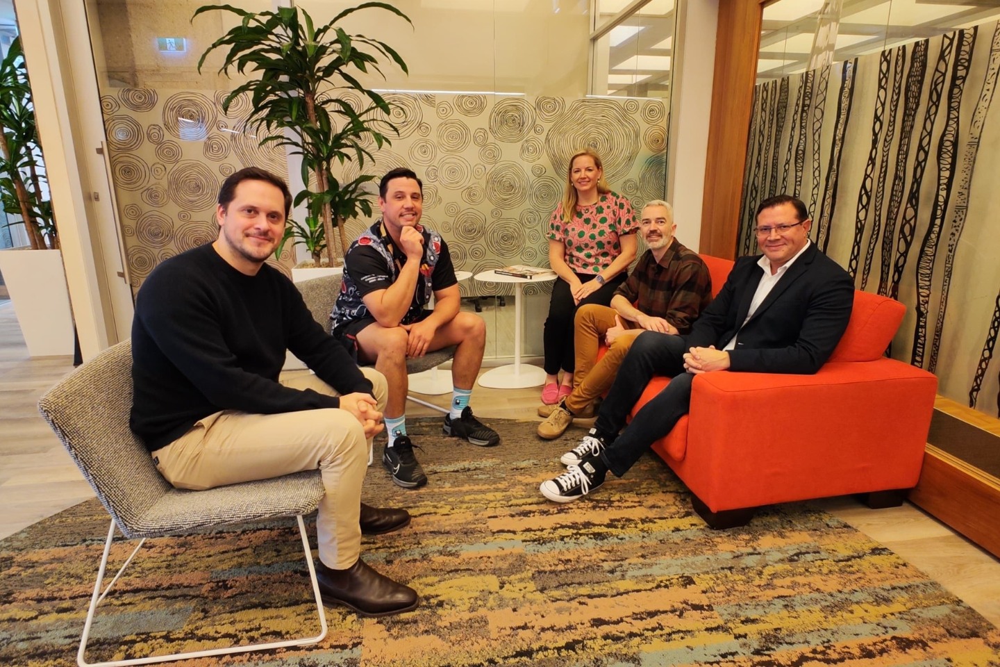 5 people sit on comfortable chairs in a room decorated with artworks and colours reflecting the natural environment in Australia and Aboriginal heritage. They are Lachlan McDaniel- Associate Dean of Research, Jumbunna, University of Technology Sydney; Dr James Beaufils- Senior Research Fellow, Jumbunna, UTS; Dr Rebecca Taylor- Senior Research Fellow, ACER; Dr Daniel Edwards- Head of Division, Education Research, Policy & Development, ACER and Lindon Coombes- Director Jumbunna Research, Jumbunna, UTS.